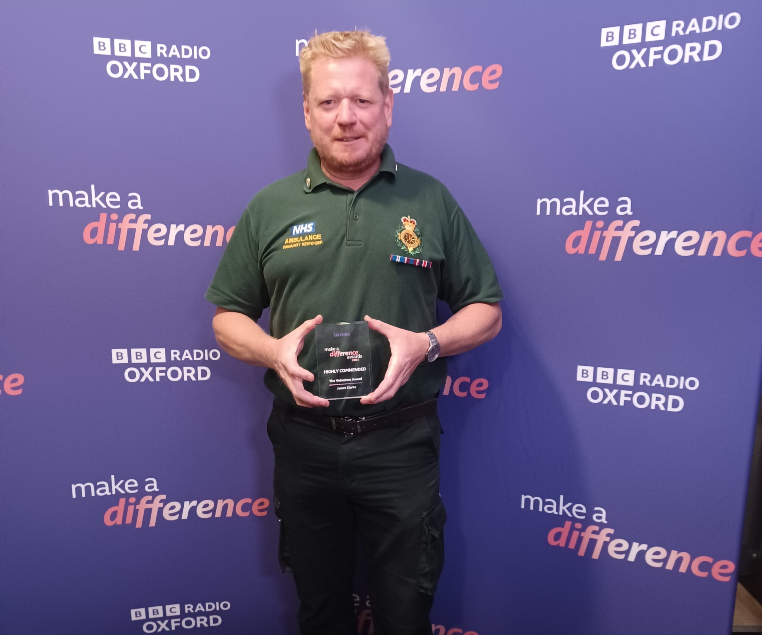 A man in community first responder uniform holding an award