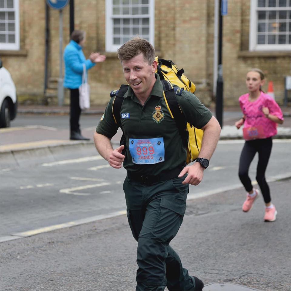 A man in green uniform running with a response pack on his back